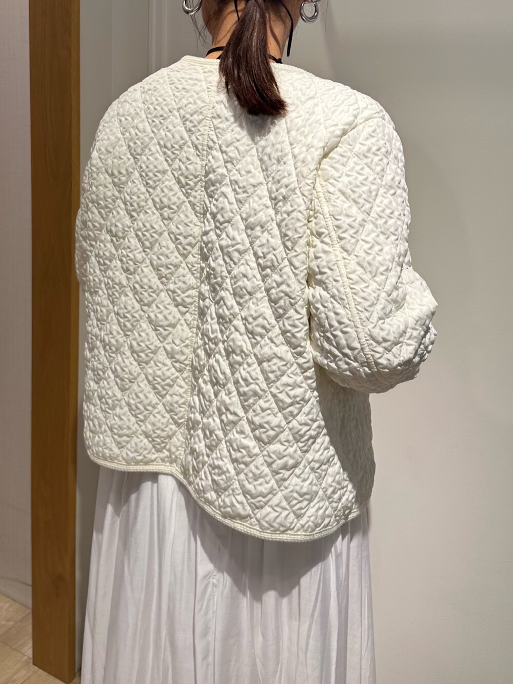 ホワイト系のブルゾン、ブルー系のニット/セーター、ホワイト系のスカートを着用したレディースの冬コーディネートの7枚目の写真