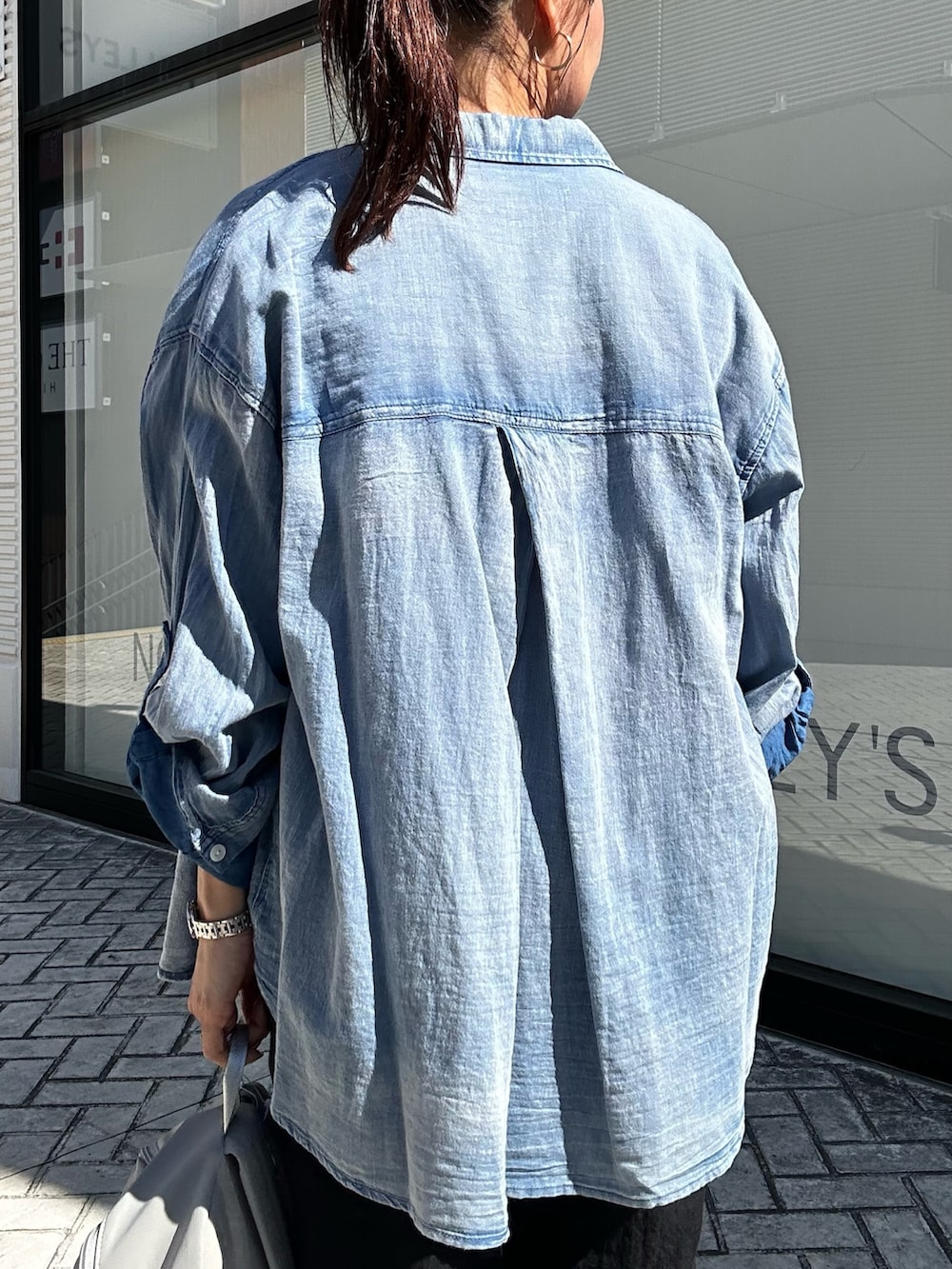 ブルー系のシャツ/ブラウス、ブルー系のTシャツ/カットソー、グレー系のバックパック/リュックを着用したレディースの春コーディネートの8枚目の写真
