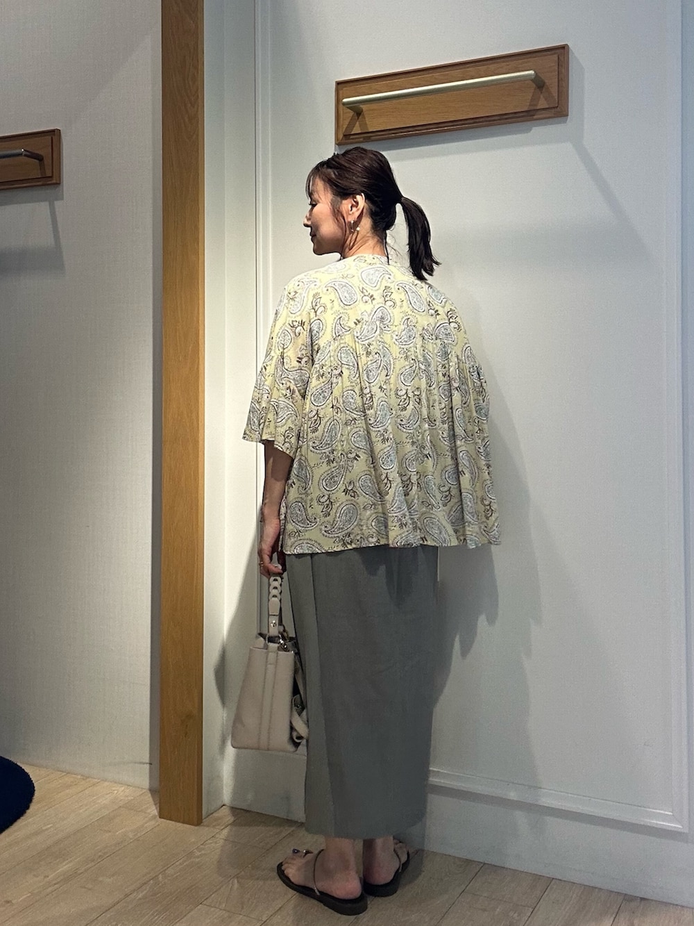 グリーン系のスカート、ブラウン系のシャツ/ブラウス、ホワイト系のシャツ/ブラウスを着用したレディースの夏コーディネートの2枚目の写真