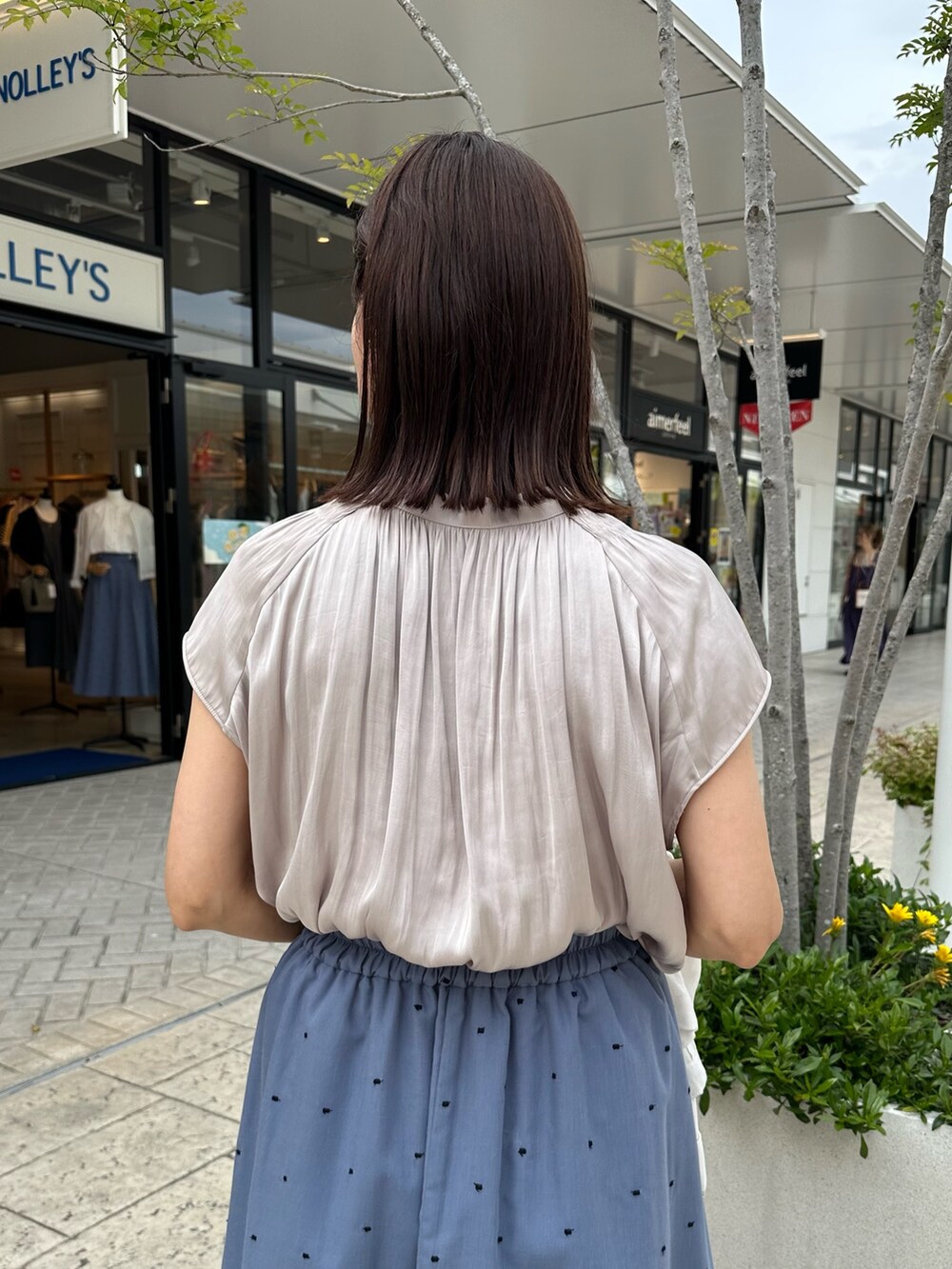 ベージュ系のシャツ/ブラウス、ブルー系のスカート、イエロー系のショルダーバッグを着用したレディースの春コーディネートの7枚目の写真