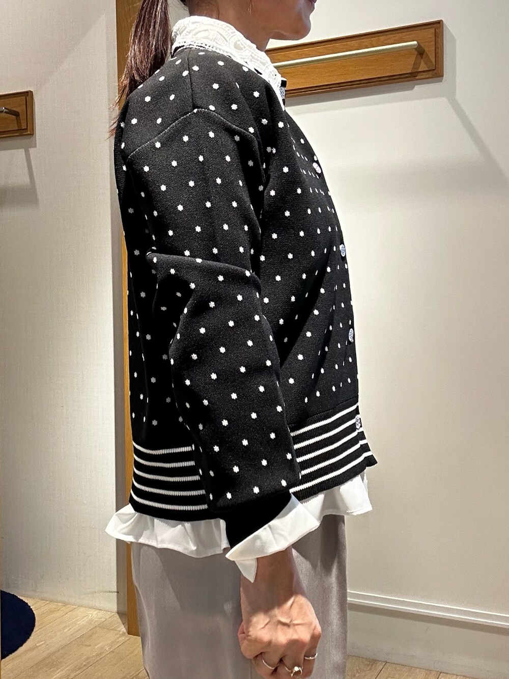 ブラック系のニット/セーター、ブラック系のショルダーバッグ、ホワイト系のシャツ/ブラウスを着用したレディースの冬コーディネートの8枚目の写真