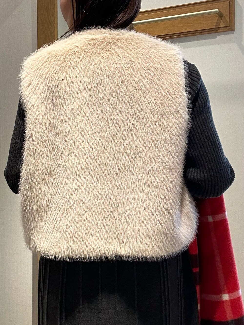 ベージュ系のブルゾン、グレー系のワンピース、ブラック系のダウンジャケット/コートを着用したレディースの冬コーディネートの6枚目の写真