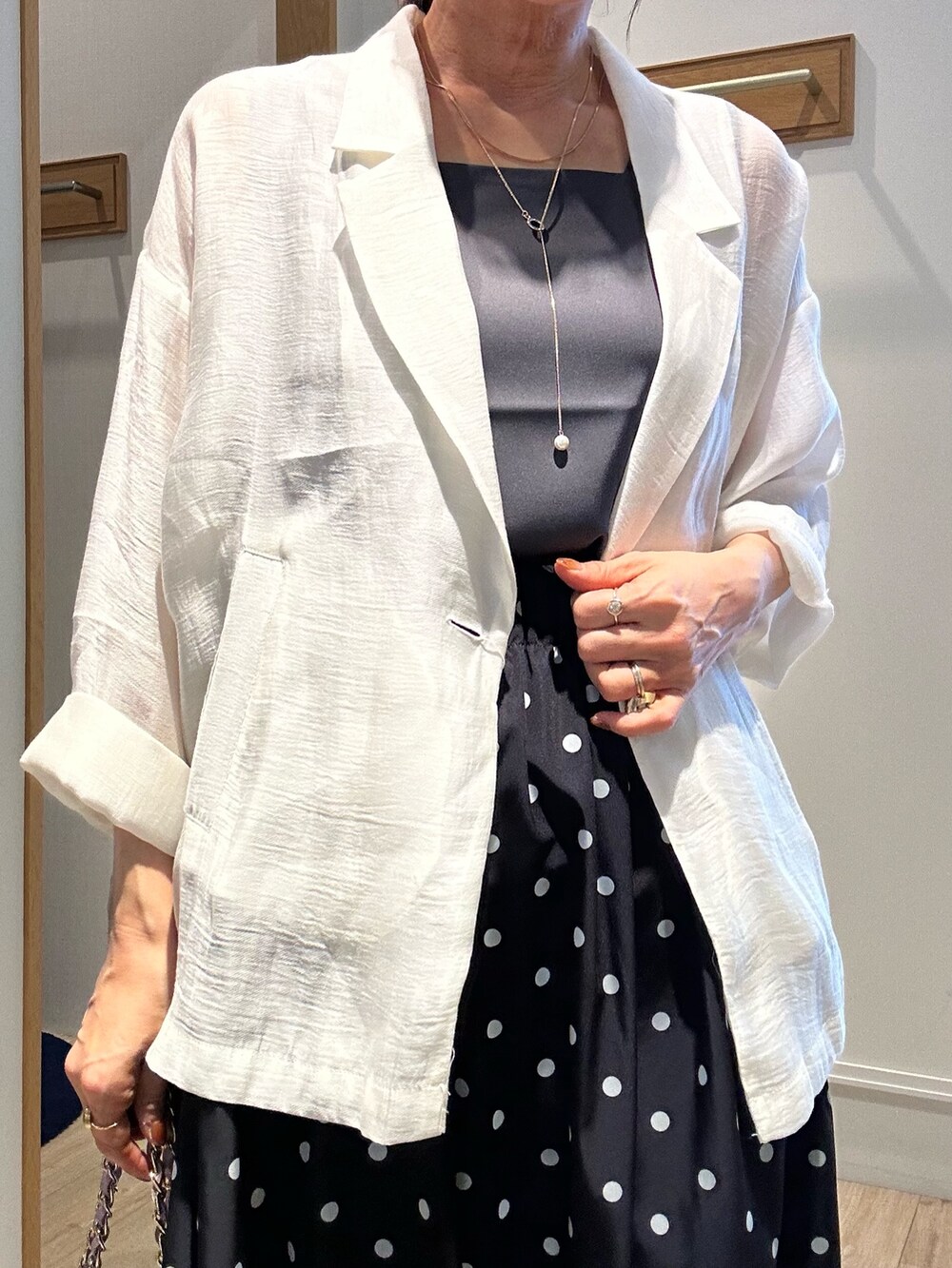 グレー系のTシャツ/カットソー、ホワイト系のテーラードジャケット、ブラック系のスカートを着用したレディースの春コーディネートの7枚目の写真