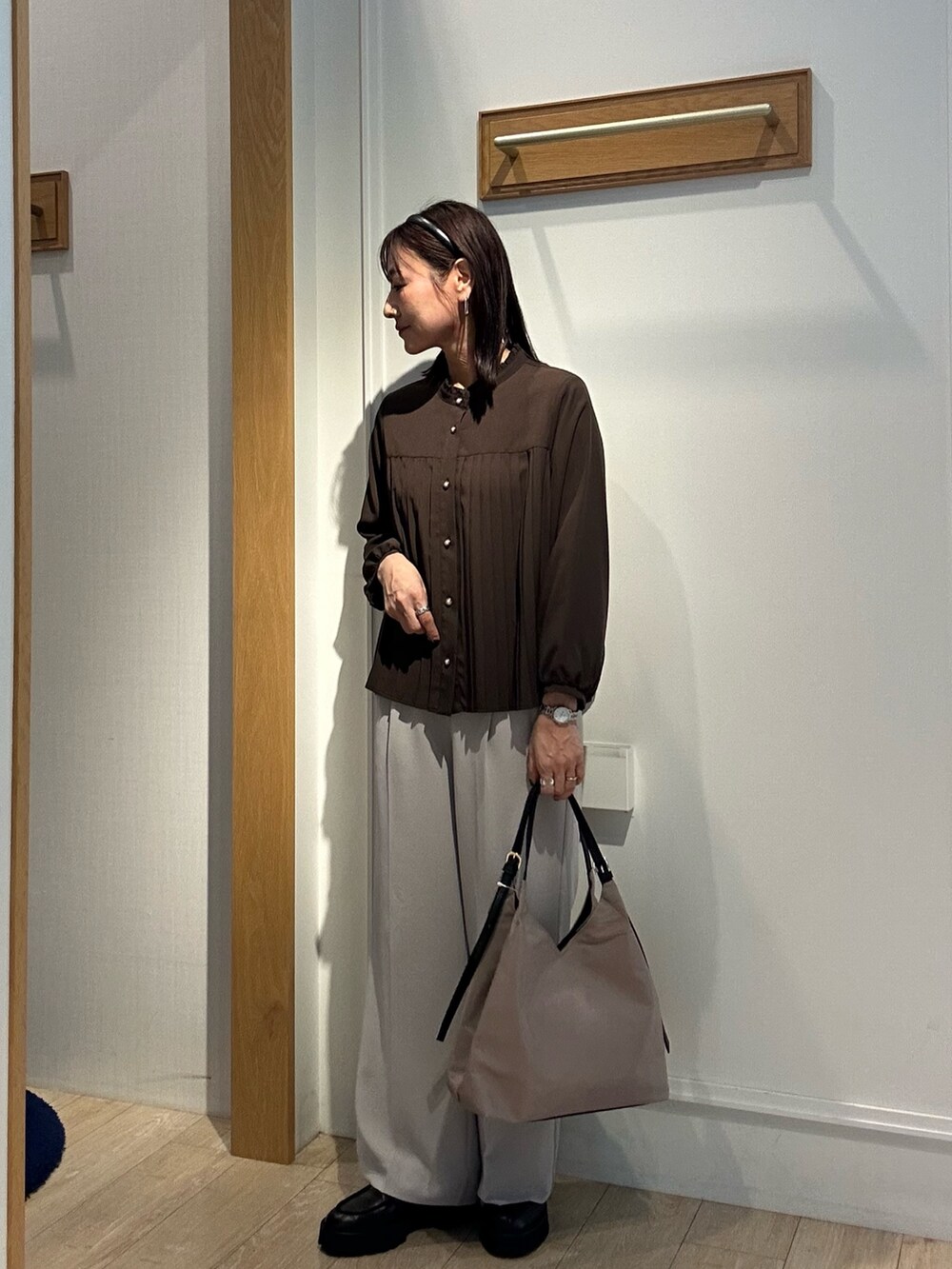 ブラウン系のシャツ/ブラウス、ベージュ系のその他パンツ、ベージュ系のトートバッグを着用したレディースの秋コーディネートの3枚目の写真