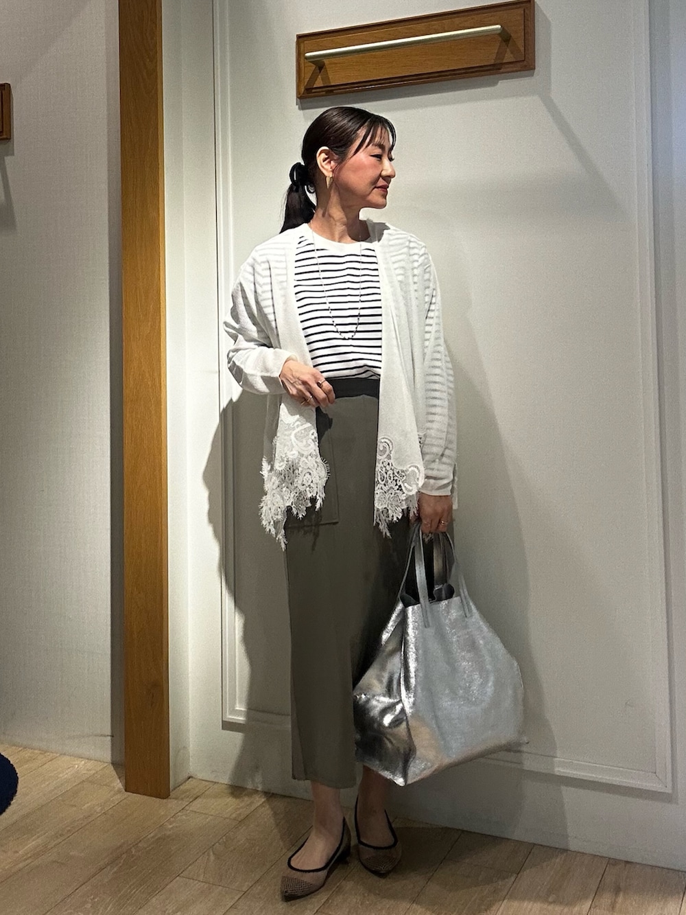 ホワイト系のTシャツ/カットソー、ホワイト系のカーディガン/ボレロ、グリーン系のスカートを着用したレディースの冬コーディネートの9枚目の写真