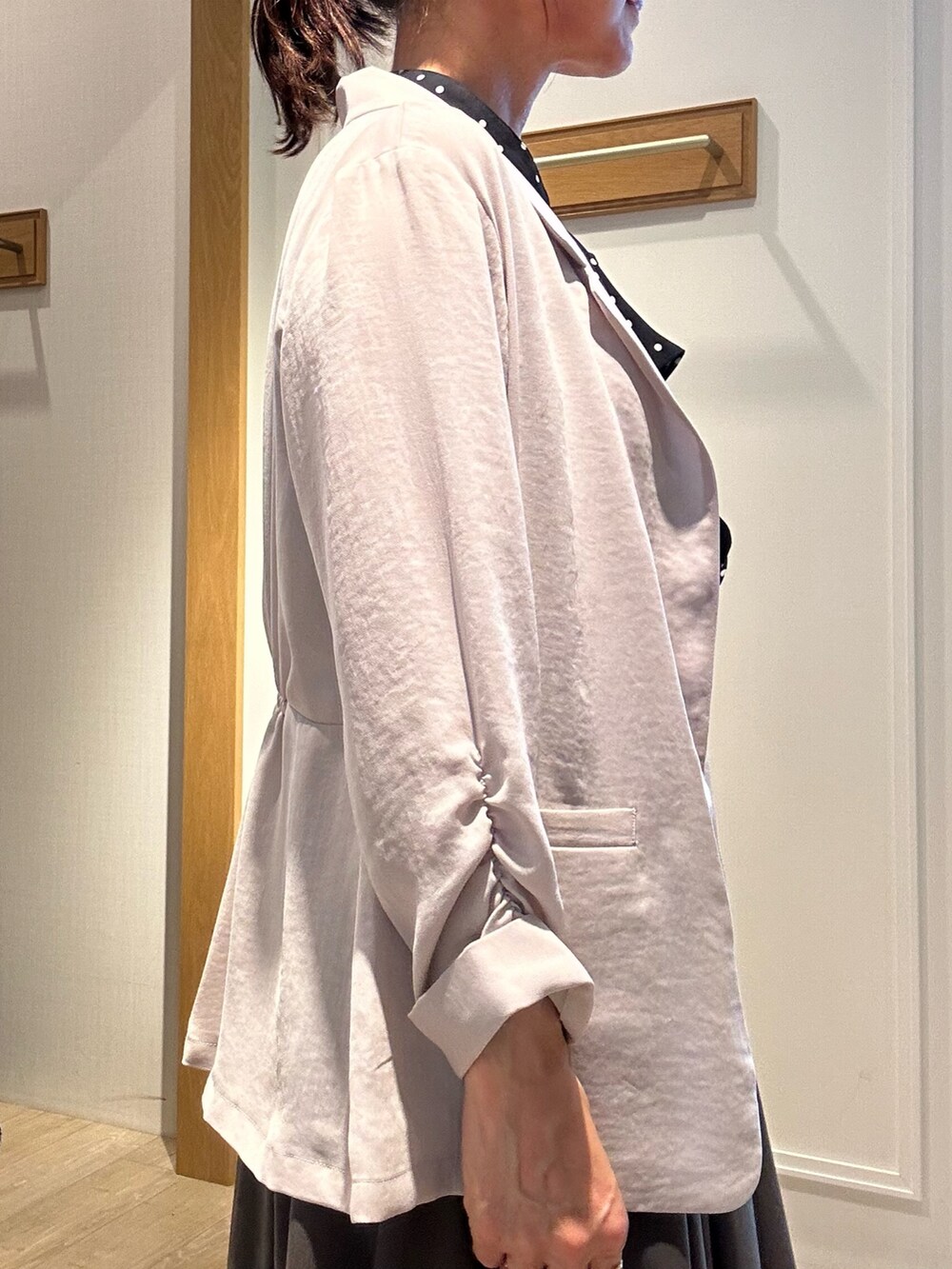 ベージュ系のテーラードジャケット、ベージュ系のボストンバッグ、ブラック系のサンダルを着用したレディースの夏コーディネートの7枚目の写真