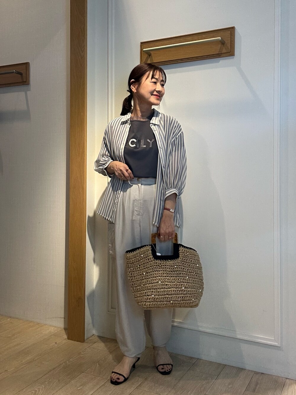 ブルー系のシャツ/ブラウス、ベージュ系のその他パンツ、ブラック系のハットを着用したレディースの春コーディネートの2枚目の写真