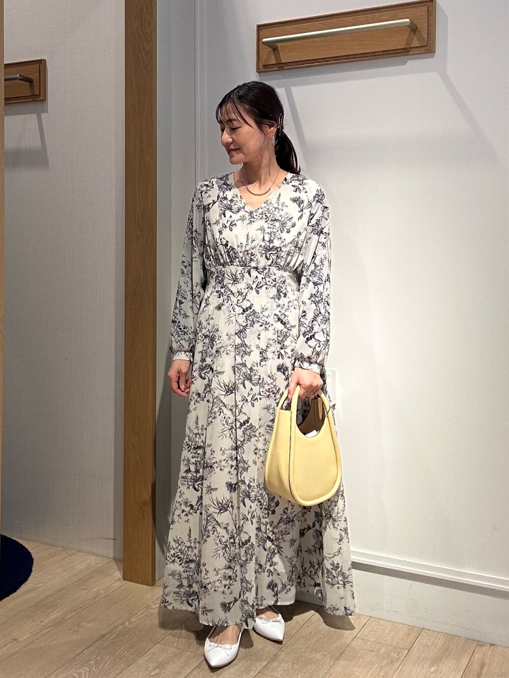 ベージュ系のワンピース、ブルー系のテーラードジャケットを着用したレディースの春コーディネートの2枚目の写真