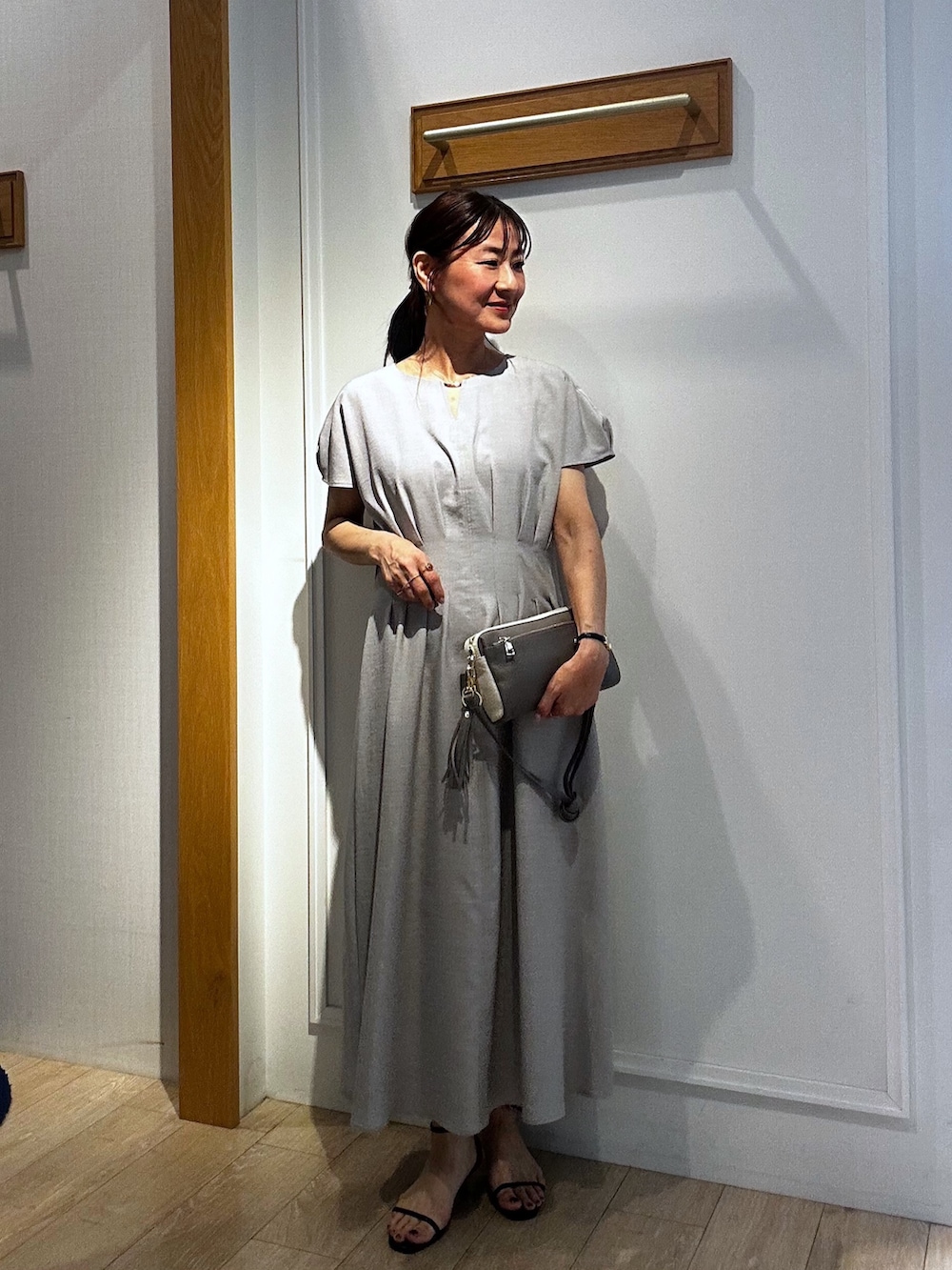 ベージュ系のワンピース、ブルー系のカーディガン/ボレロ、グレー系のショルダーバッグを着用したレディースの春コーディネートの5枚目の写真