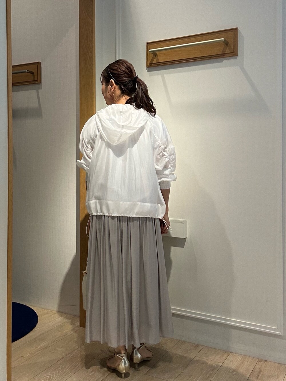 ベージュ系のスカート、ホワイト系のブルゾン、ホワイト系のTシャツ/カットソーを着用したレディースの春コーディネートの3枚目の写真