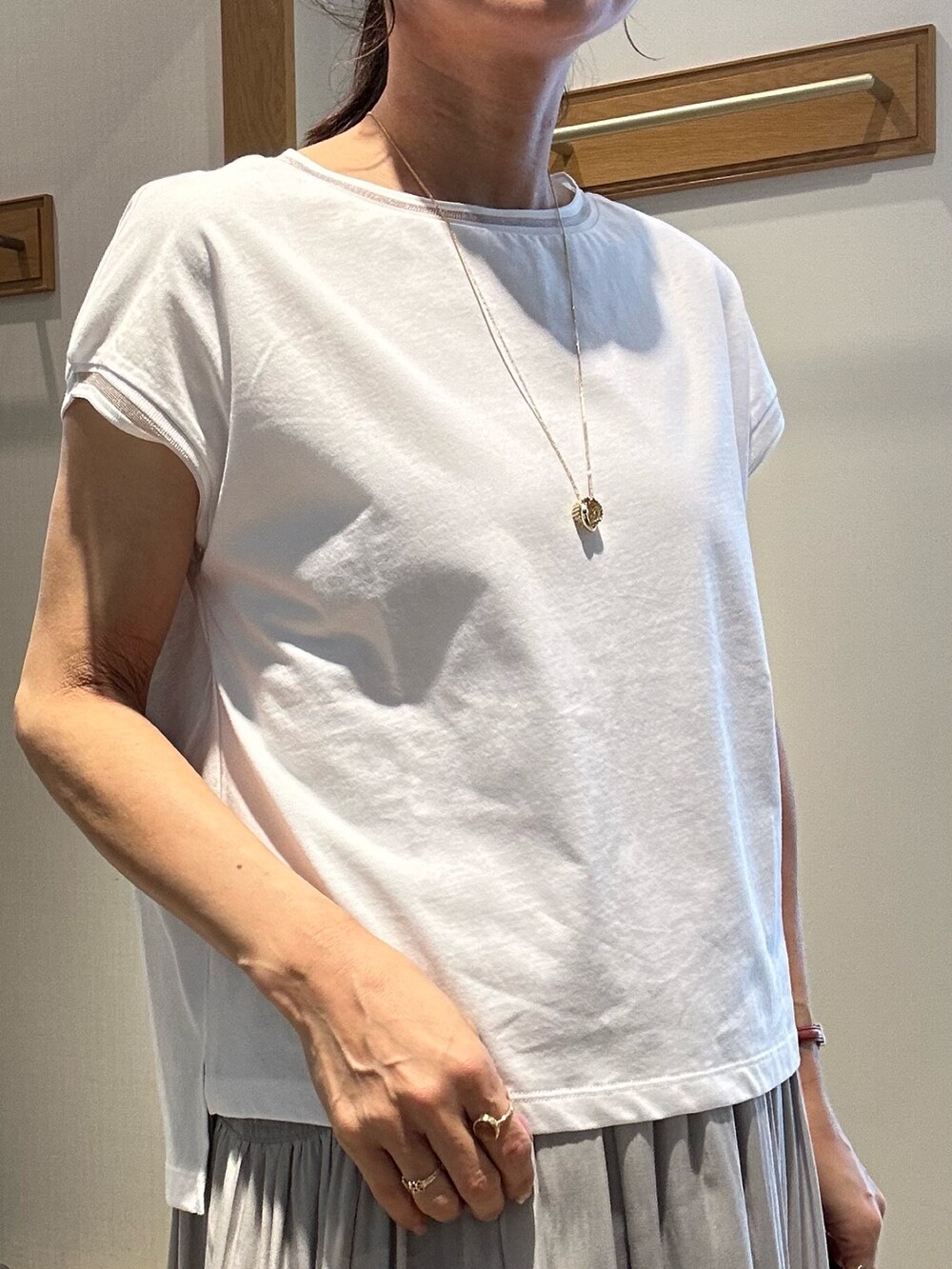 ホワイト系のTシャツ/カットソー、ベージュ系のスカート、ホワイト系のブルゾンを着用したレディースの春コーディネートの4枚目の写真