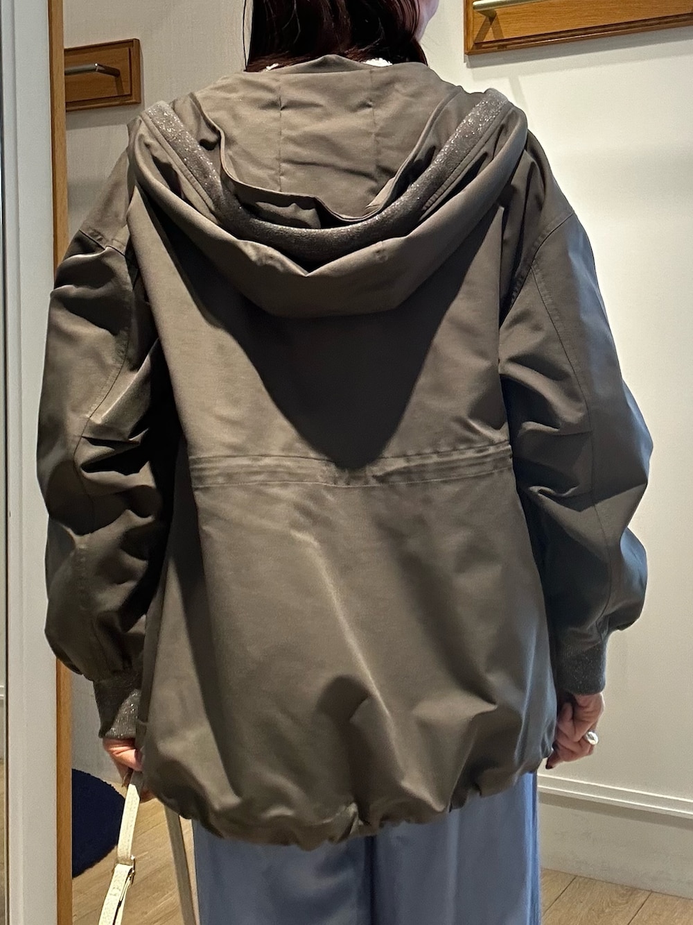 グリーン系のブルゾン、ホワイト系のシャツ/ブラウス、ブルー系のデニムパンツを着用したレディースの冬コーディネートの5枚目の写真