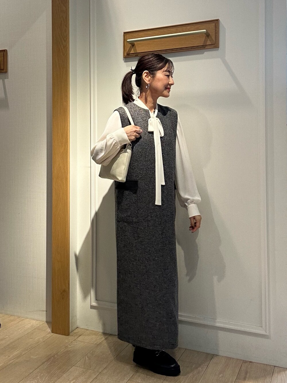 グレー系のワンピース、ホワイト系のシャツ/ブラウスを着用したレディースの秋コーディネートの2枚目の写真