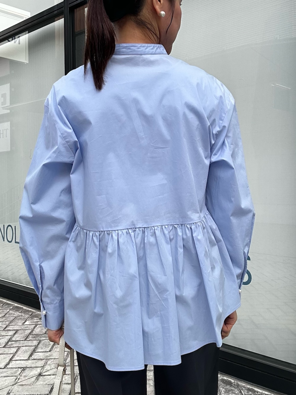 ホワイト系のショルダーバッグ、ベージュ系のブルゾン、ブルー系のテーラードジャケットを着用したレディースの春コーディネートの6枚目の写真