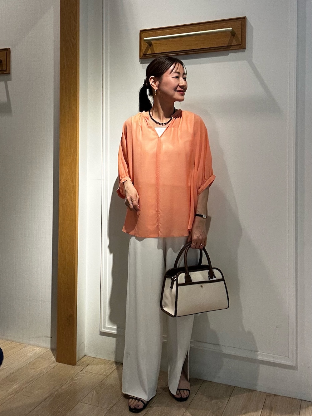 ブラウン系のトートバッグ、ホワイト系のTシャツ/カットソー、グレー系のテーラードジャケットを着用したレディースの夏コーディネートの3枚目の写真