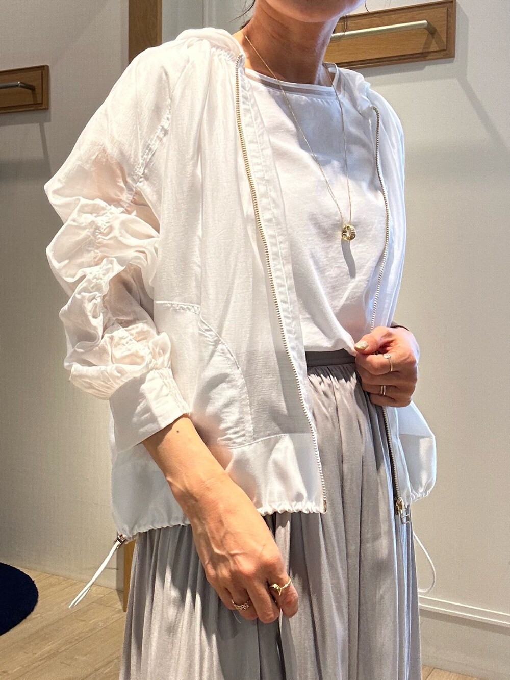 ベージュ系のスカート、ホワイト系のブルゾン、ホワイト系のTシャツ/カットソーを着用したレディースの春コーディネートの7枚目の写真