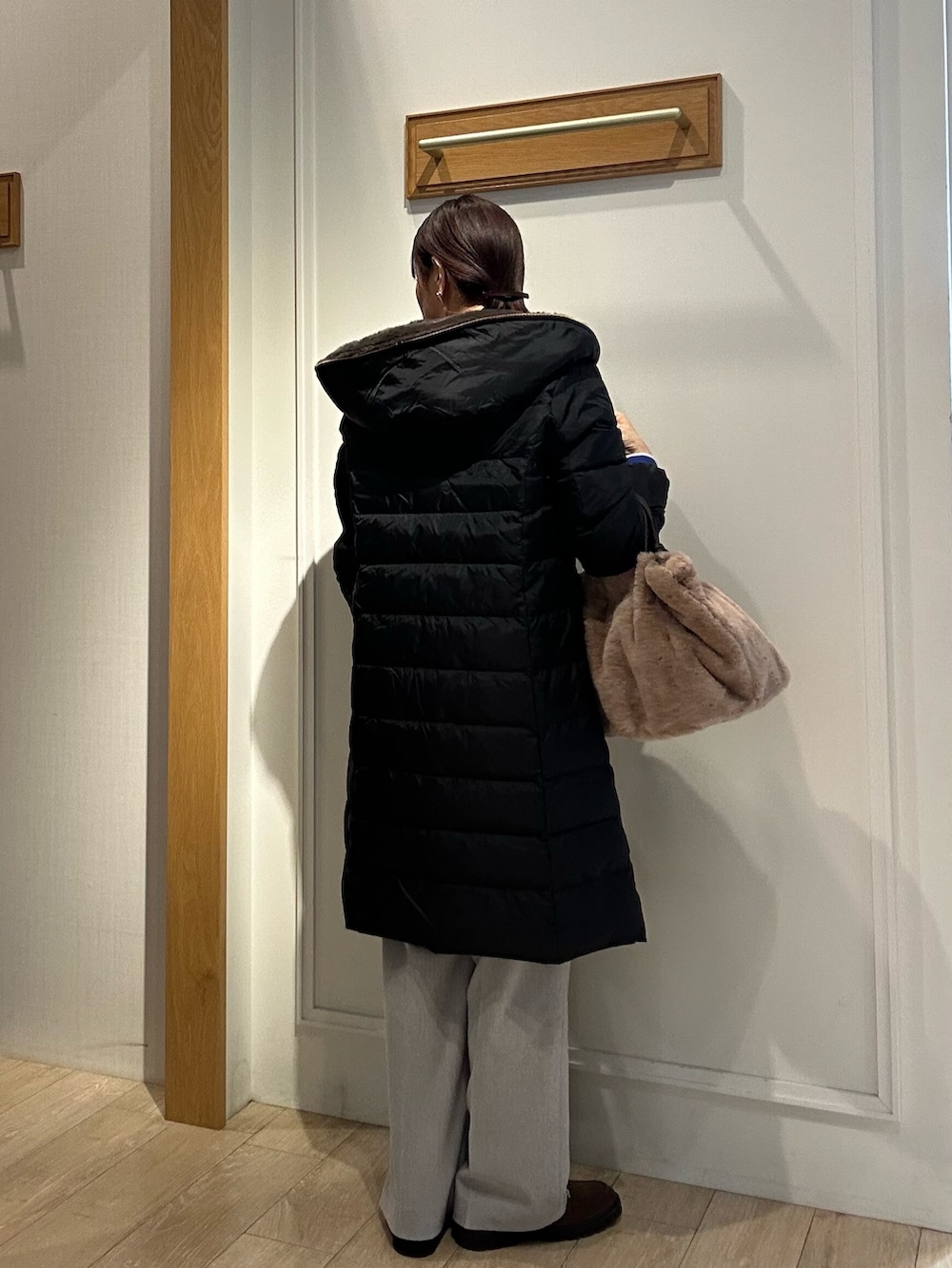 ブラウン系のローファー、ブラック系のダウンジャケット/コート、ブルー系のカーディガン/ボレロを着用したレディースの冬コーディネートの3枚目の写真