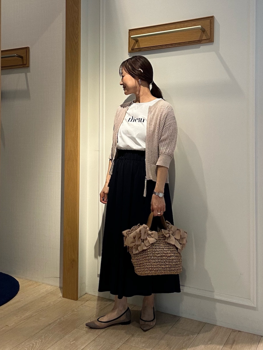 ベージュ系のニット/セーター、ホワイト系のTシャツ/カットソー、ブルー系のスカートを着用したレディースの春コーディネートの2枚目の写真