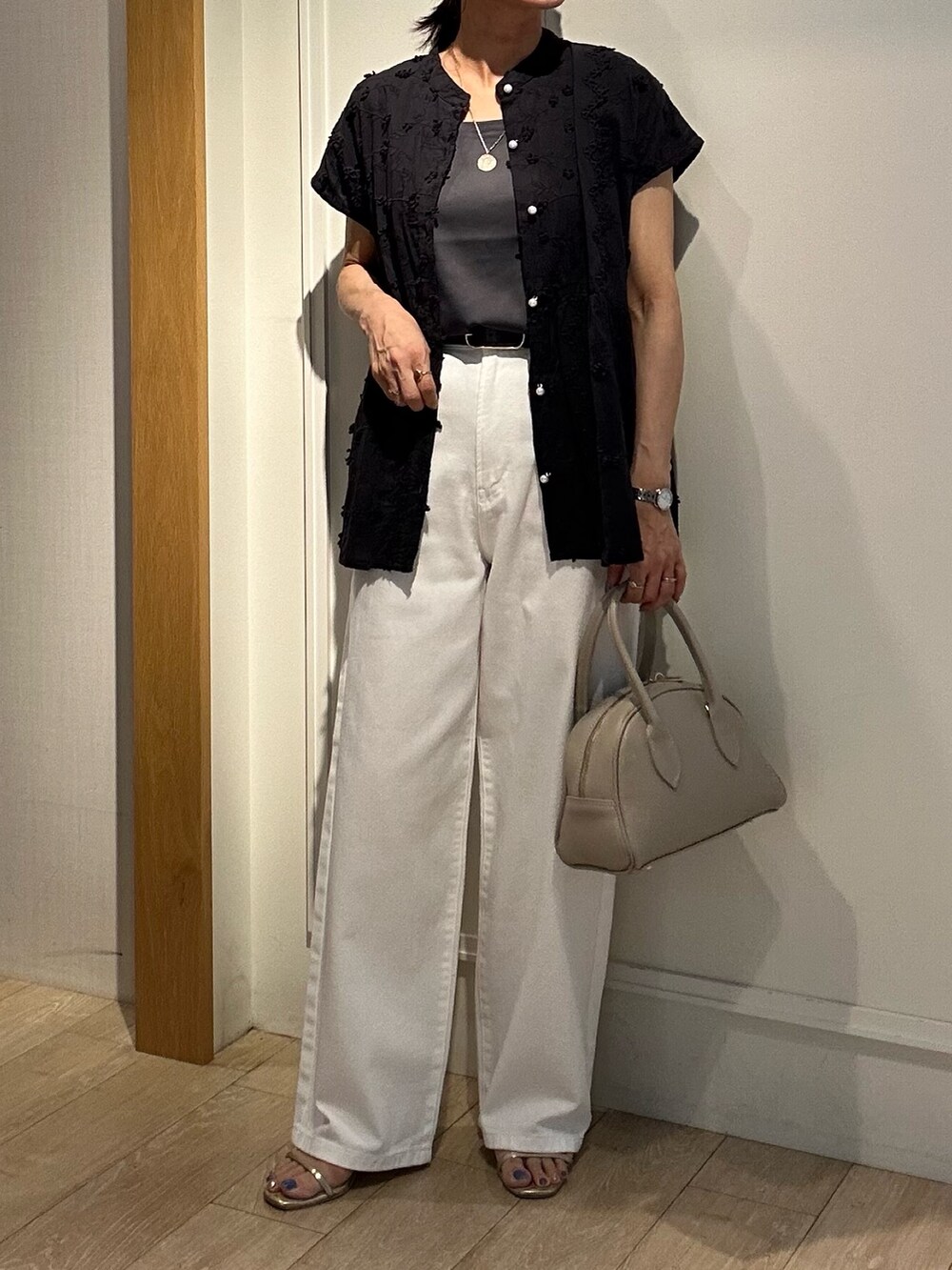 ブラック系のシャツ/ブラウス、ホワイト系のデニムパンツ、ベージュ系のボストンバッグを着用したレディースの夏コーディネートの6枚目の写真