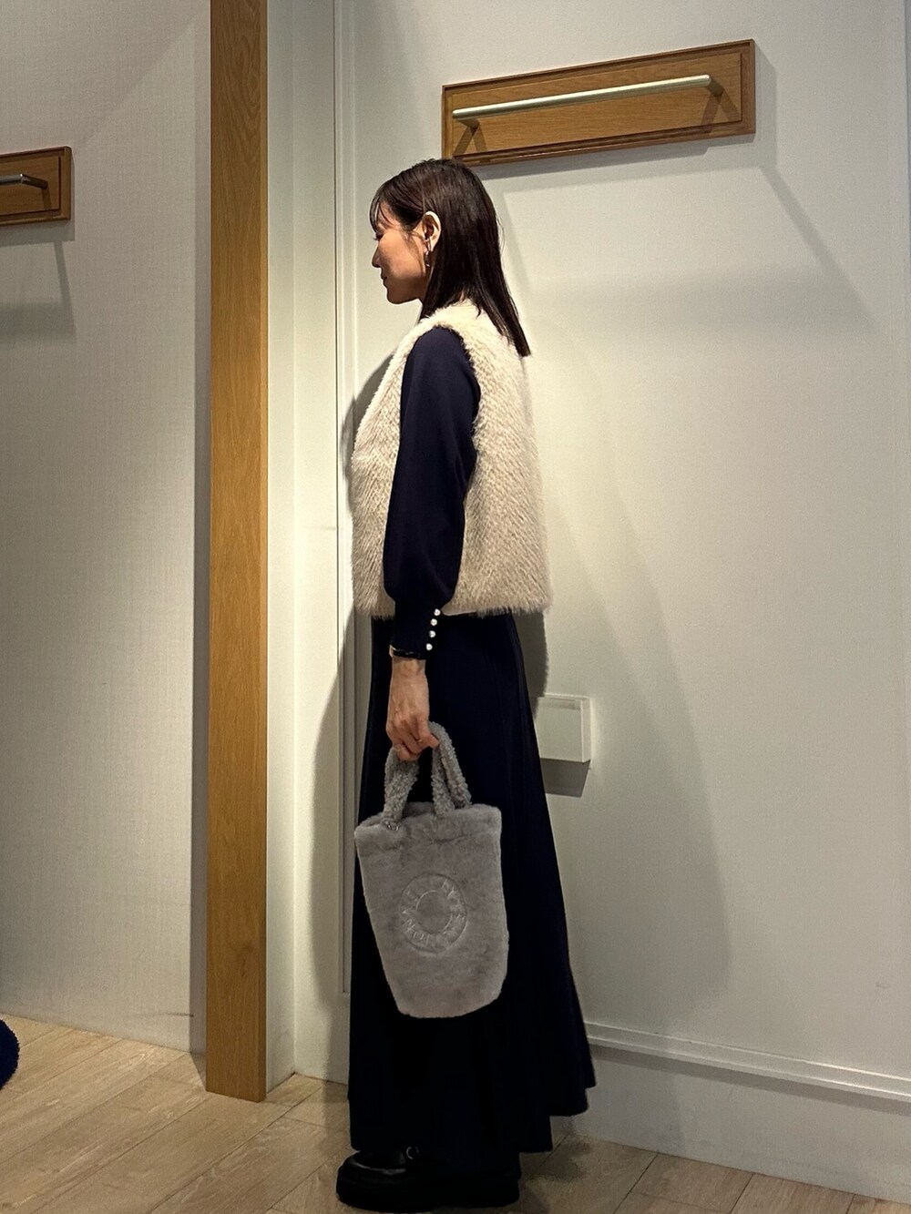 ブルー系のワンピース、グレー系のトートバッグ、ベージュ系のブルゾンを着用したレディースの秋コーディネートの7枚目の写真