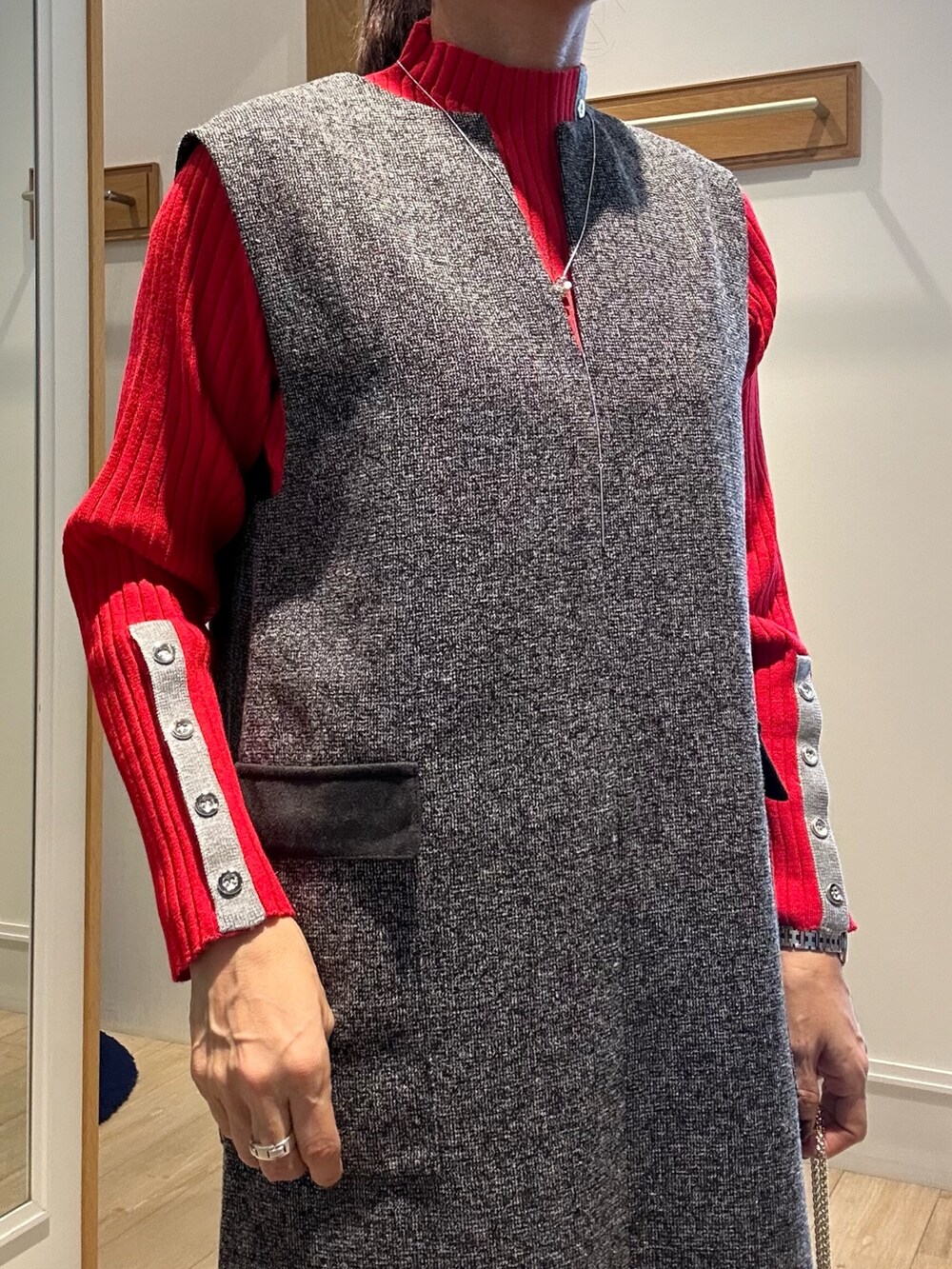 グレー系のワンピース、レッド系のニット/セーターを着用したレディースの秋コーディネートの6枚目の写真