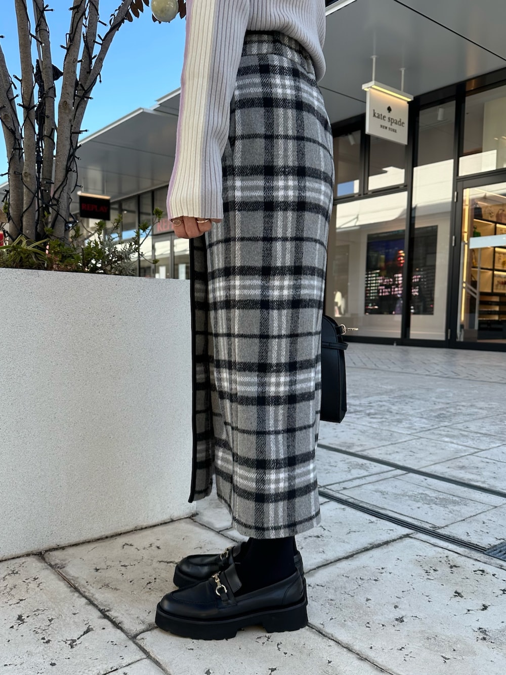 グレー系のスカート、ブラック系のトートバッグ、ピンク系のニット/セーターを着用したレディースの秋コーディネートの9枚目の写真