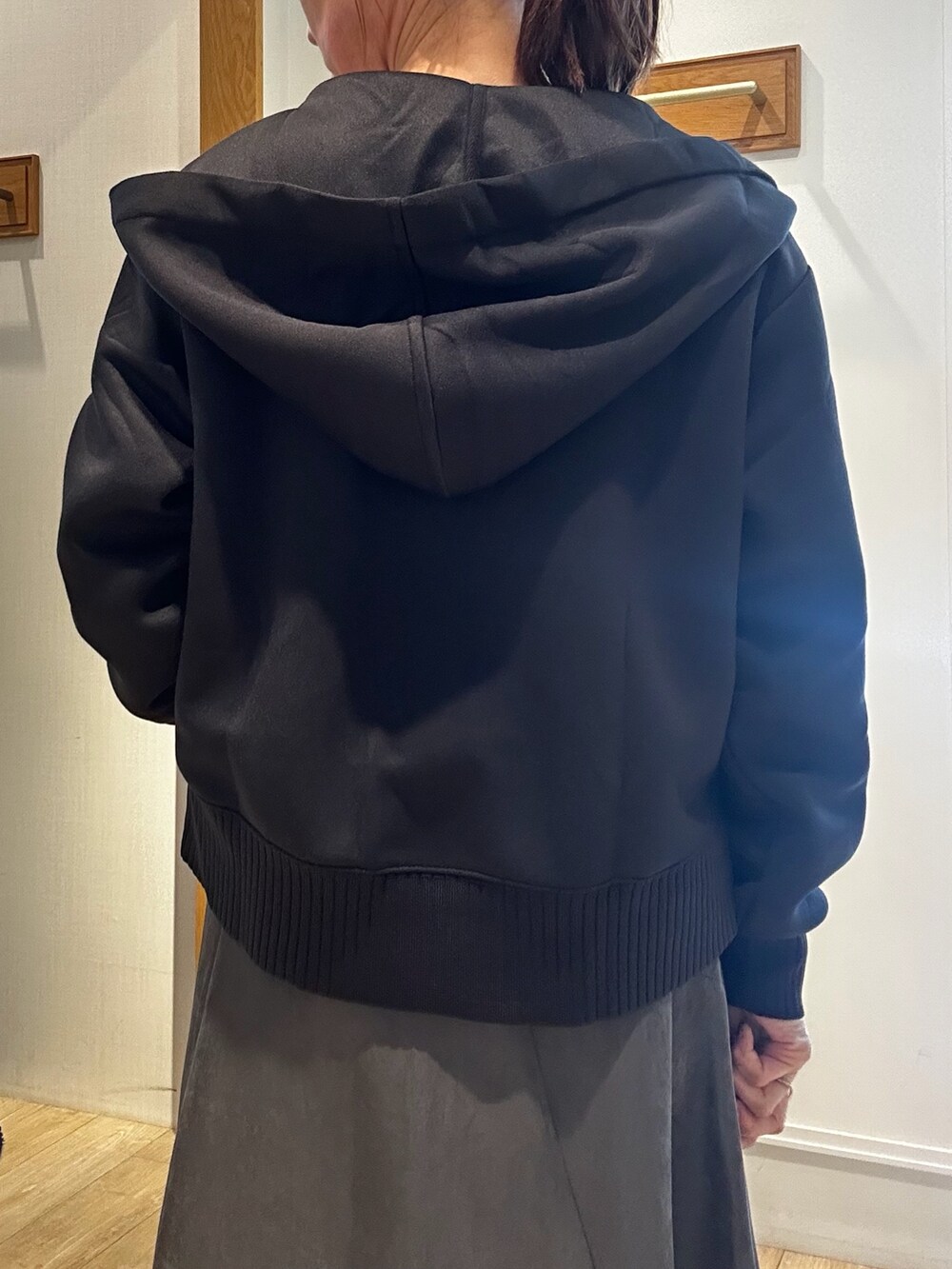 ブラック系のパーカー、ホワイト系のニット/セーター、ブラウン系のシャツ/ブラウスを着用したレディースの秋コーディネートの7枚目の写真