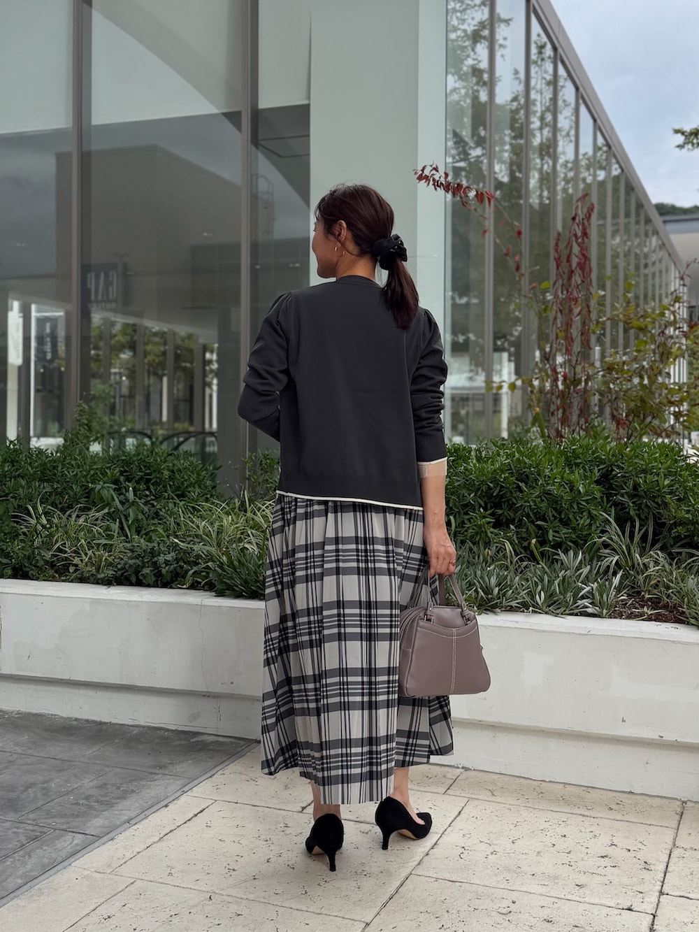 グレー系のカーディガン/ボレロ、ホワイト系のTシャツ/カットソー、ホワイト系のスカートを着用したレディースの秋コーディネートの3枚目の写真