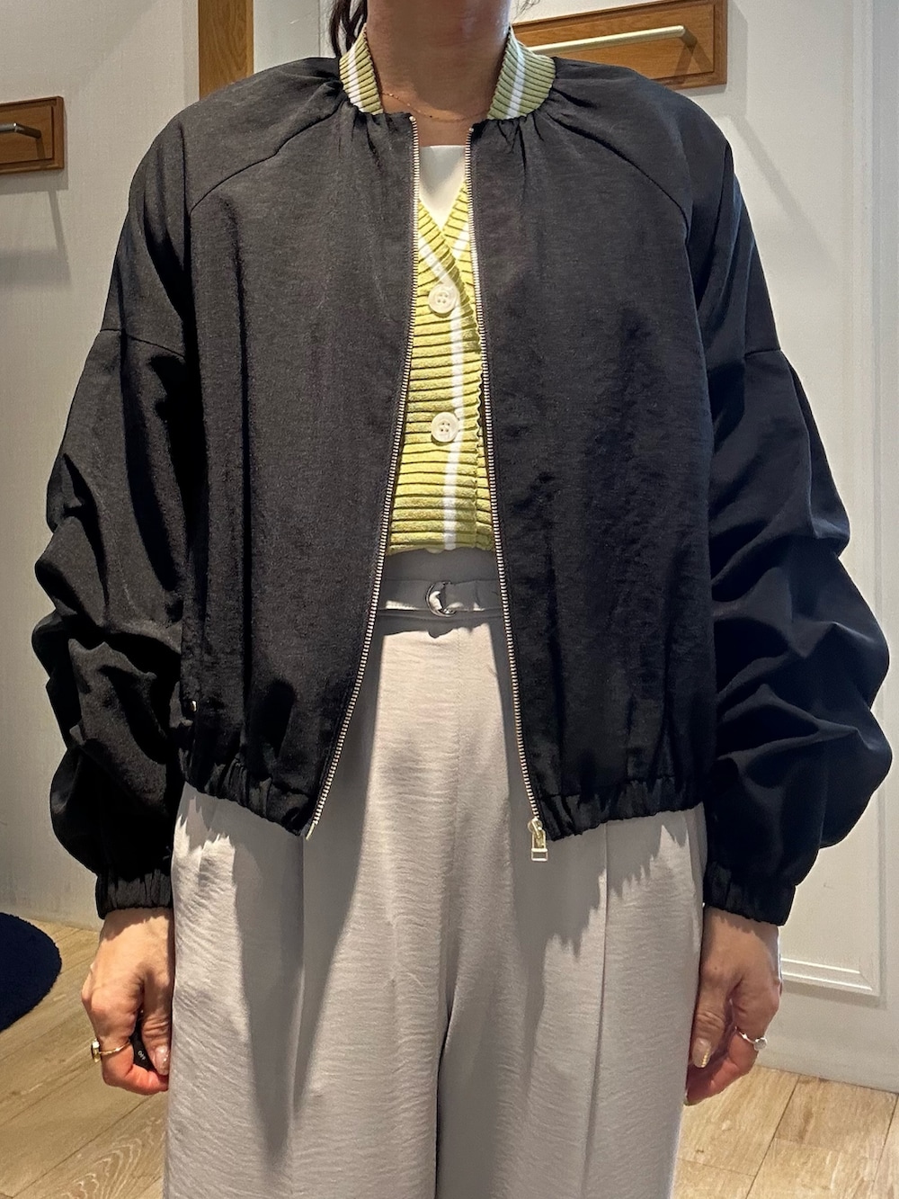 ベージュ系のその他パンツ、イエロー系のカーディガン/ボレロ、ブラック系のブルゾンを着用したレディースの春コーディネートの5枚目の写真