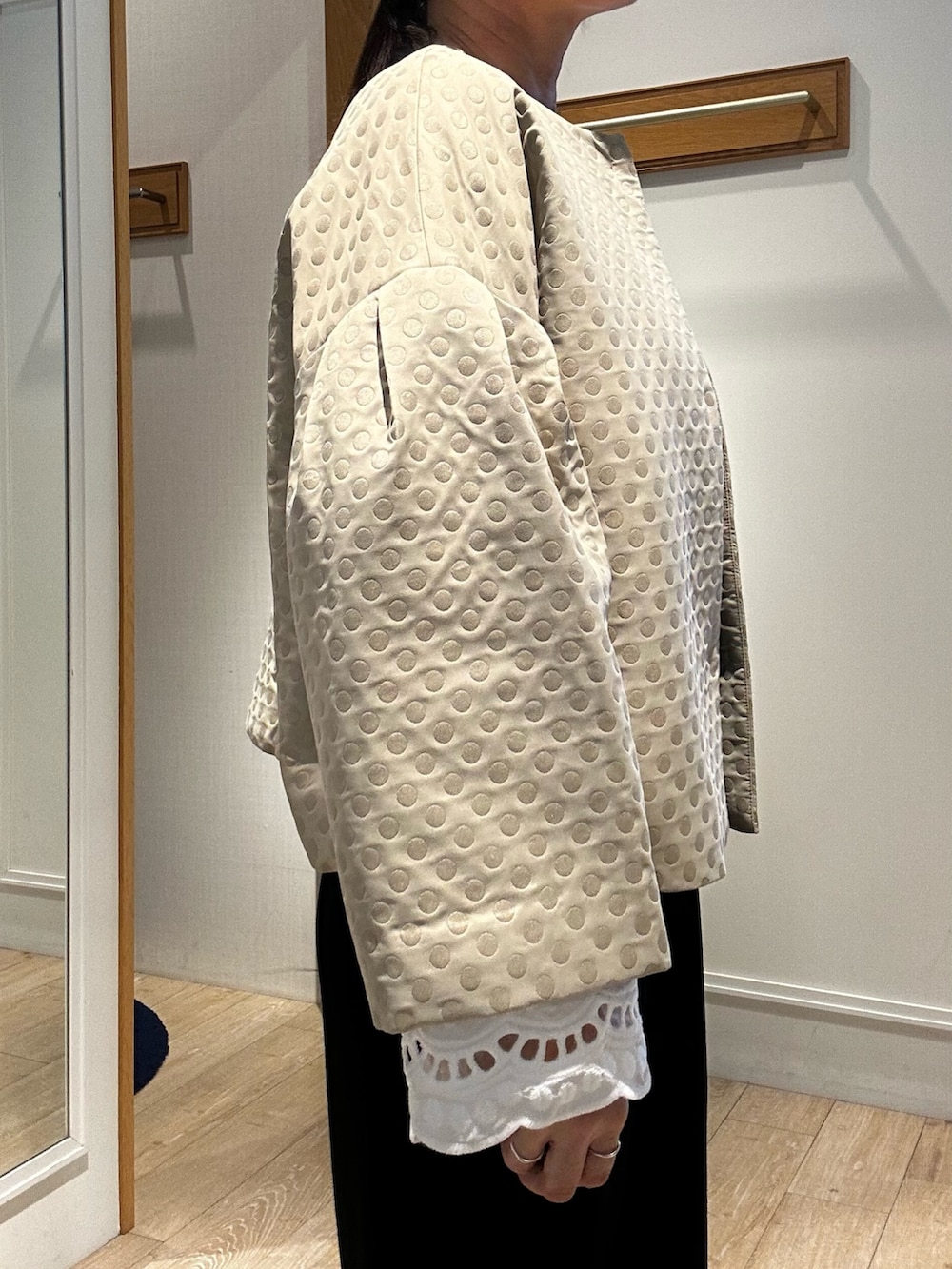 ホワイト系のショルダーバッグ、ホワイト系のシャツ/ブラウス、ベージュ系のブルゾンを着用したレディースの冬コーディネートの5枚目の写真