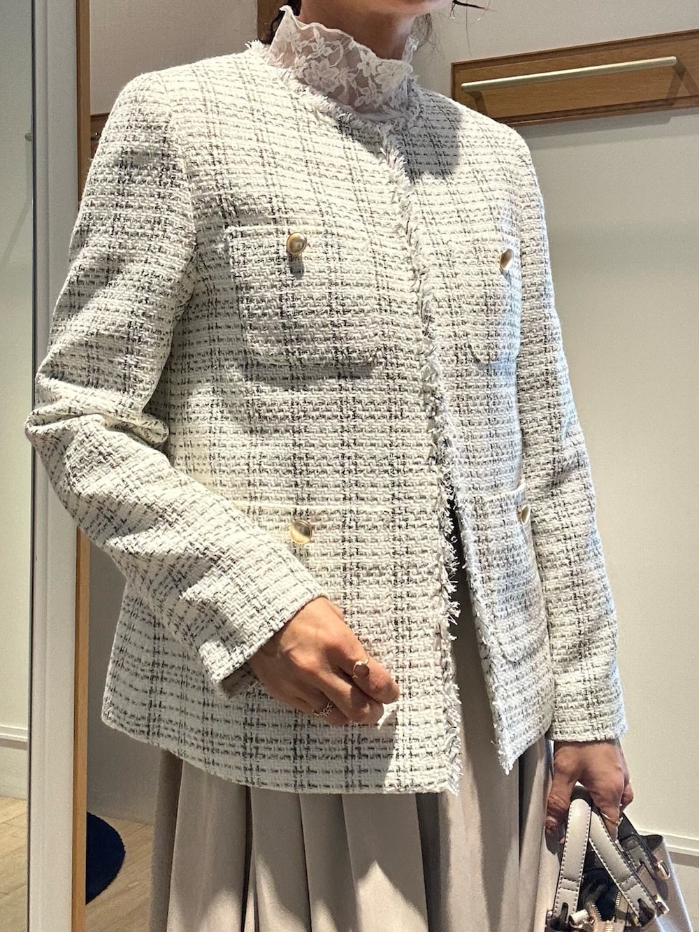 ホワイト系のノーカラージャケット、ブルー系のスカートを着用したレディースの冬コーディネートの6枚目の写真