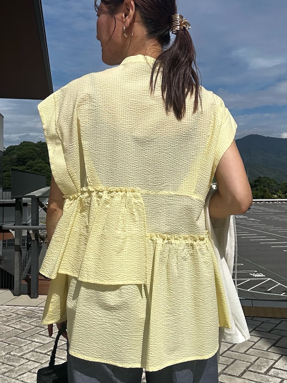 イエロー系のシャツ/ブラウス、ブルー系のその他パンツ、ブルー系のカーディガン/ボレロを着用したレディースの春コーディネートの8枚目の写真