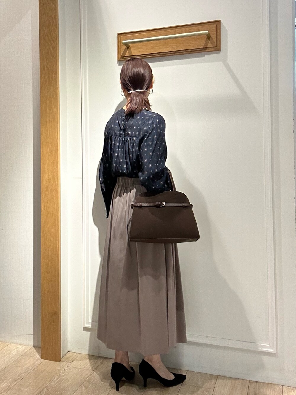 ブラウン系のスカート、ブルー系のシャツ/ブラウス、ブラウン系のトートバッグを着用したレディースの秋コーディネートの3枚目の写真