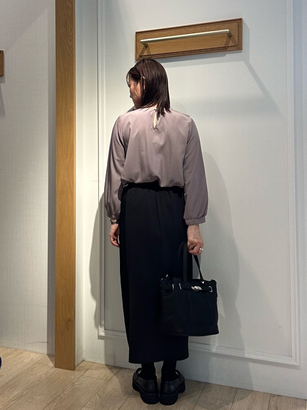 ブラウン系のシャツ/ブラウス、ブラック系のスカート、ブラック系のトートバッグを着用したレディースの秋コーディネートの3枚目の写真