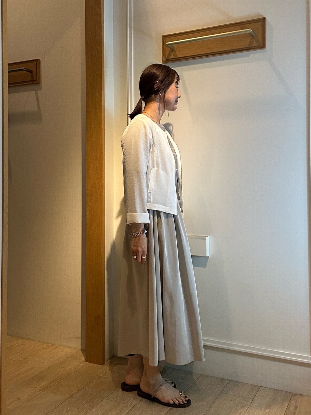 ホワイト系のブルゾン、グレー系のTシャツ/カットソー、グリーン系のスカートを着用したレディースの春コーディネートの3枚目の写真