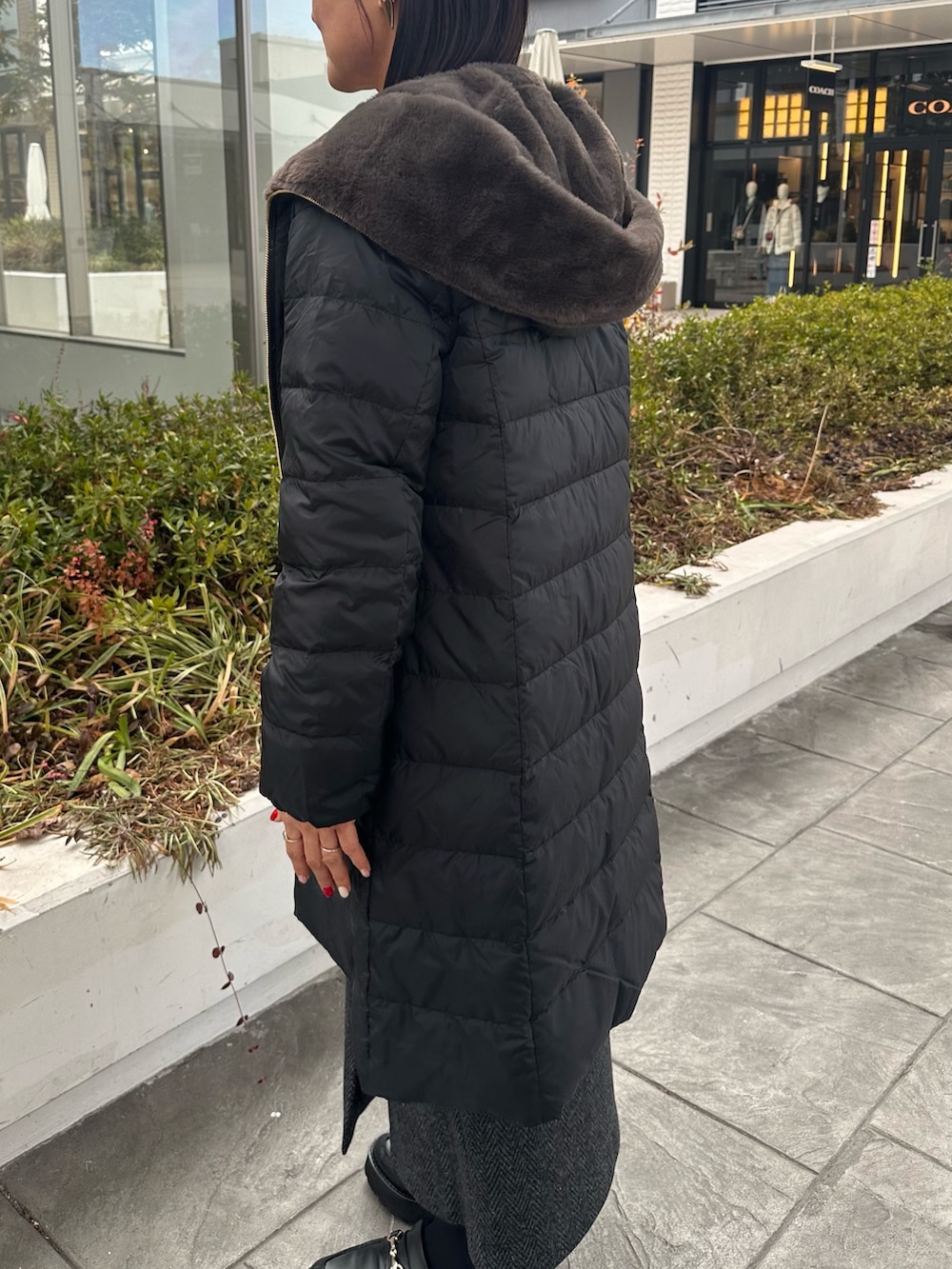 ブラウン系のローファー、ブラック系のダウンジャケット/コート、ブルー系のカーディガン/ボレロを着用したレディースの冬コーディネートの9枚目の写真