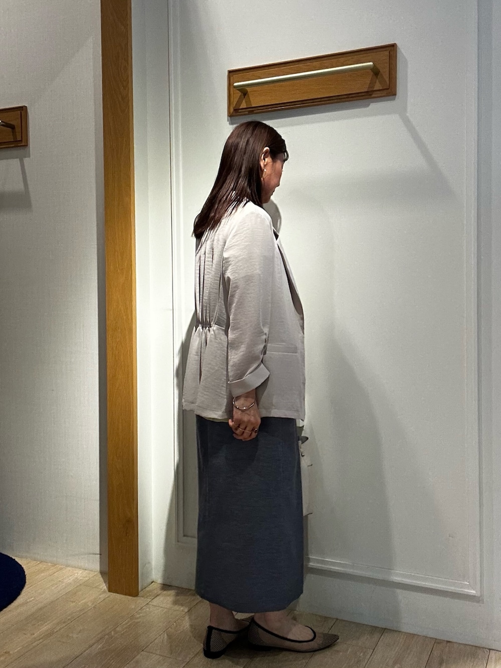 ブルー系のスカート、イエロー系のシャツ/ブラウス、ベージュ系のテーラードジャケットを着用したレディースの春コーディネートの2枚目の写真