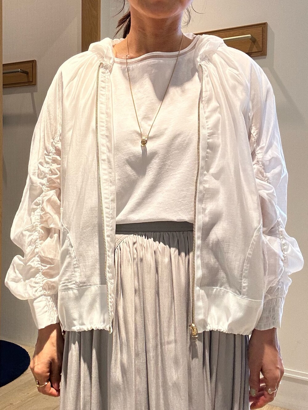 ベージュ系のスカート、ホワイト系のブルゾン、ホワイト系のTシャツ/カットソーを着用したレディースの春コーディネートの4枚目の写真