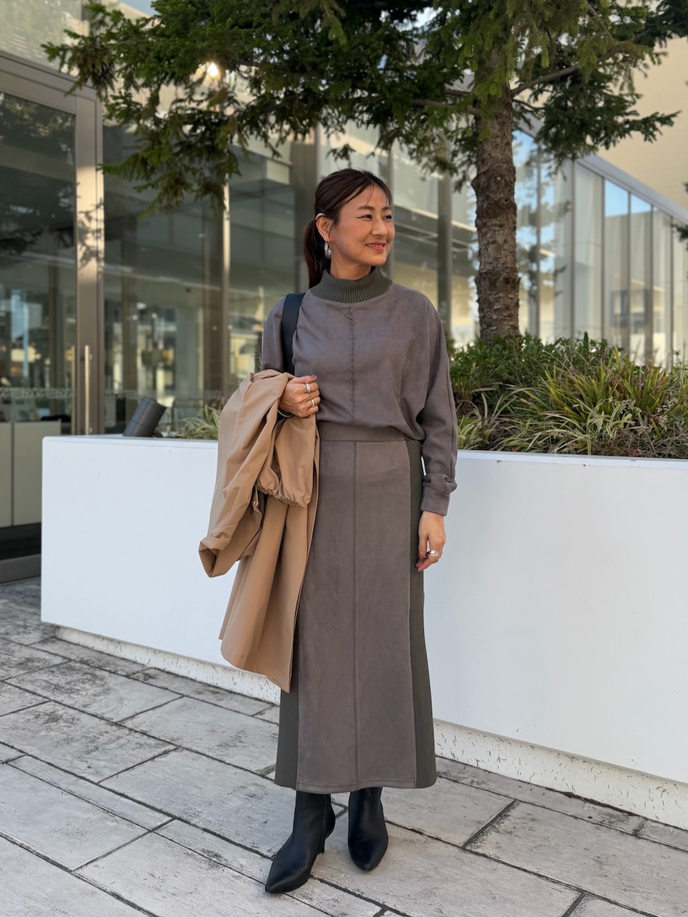 グレー系のTシャツ/カットソー、イエロー系のダッフルコート、グレー系のスカートを着用したレディースの秋コーディネートの7枚目の写真