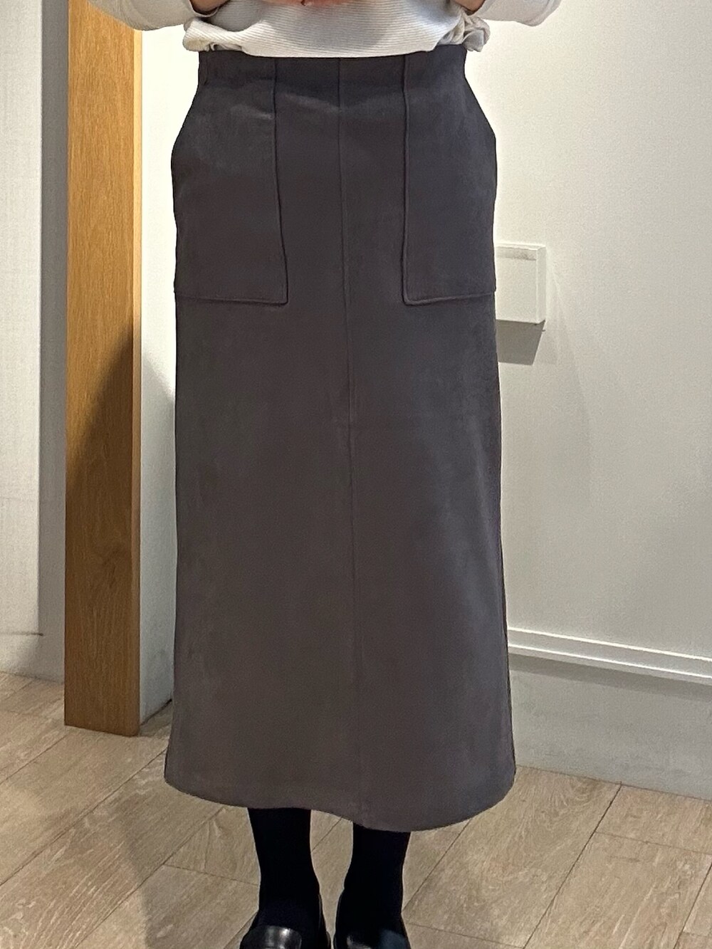 ホワイト系のニット/セーター、ブルー系のテーラードジャケット、グレー系のスカートを着用したレディースの秋コーディネートの9枚目の写真