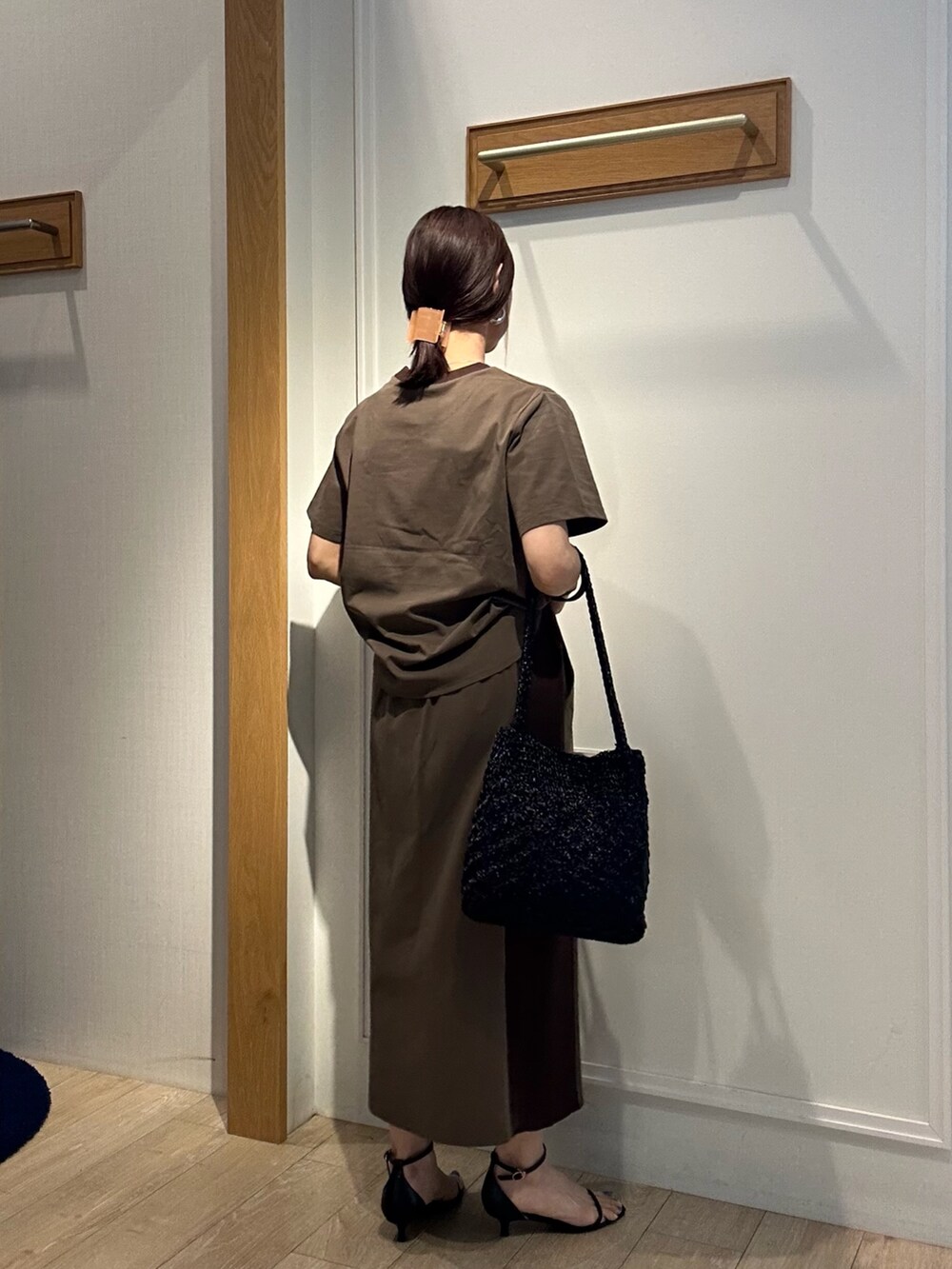 ブラウン系のTシャツ/カットソー、ブラウン系のスカート、ブラック系のサンダルを着用したレディースの夏コーディネートの3枚目の写真