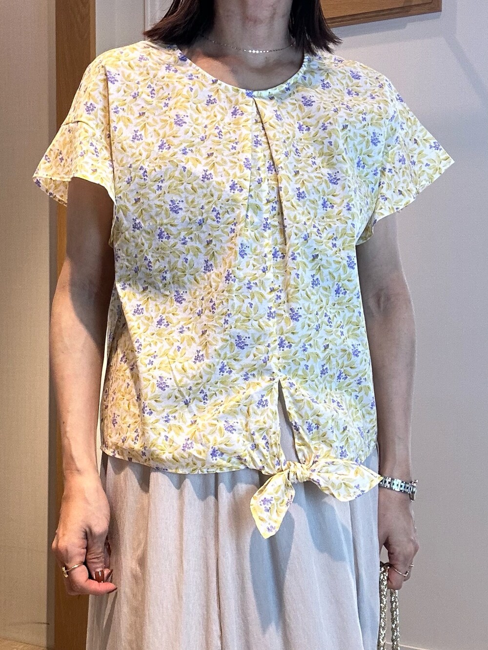 ホワイト系のスカート、イエロー系のシャツ/ブラウス、ゴールド系のネックレスを着用したレディースの春コーディネートの4枚目の写真