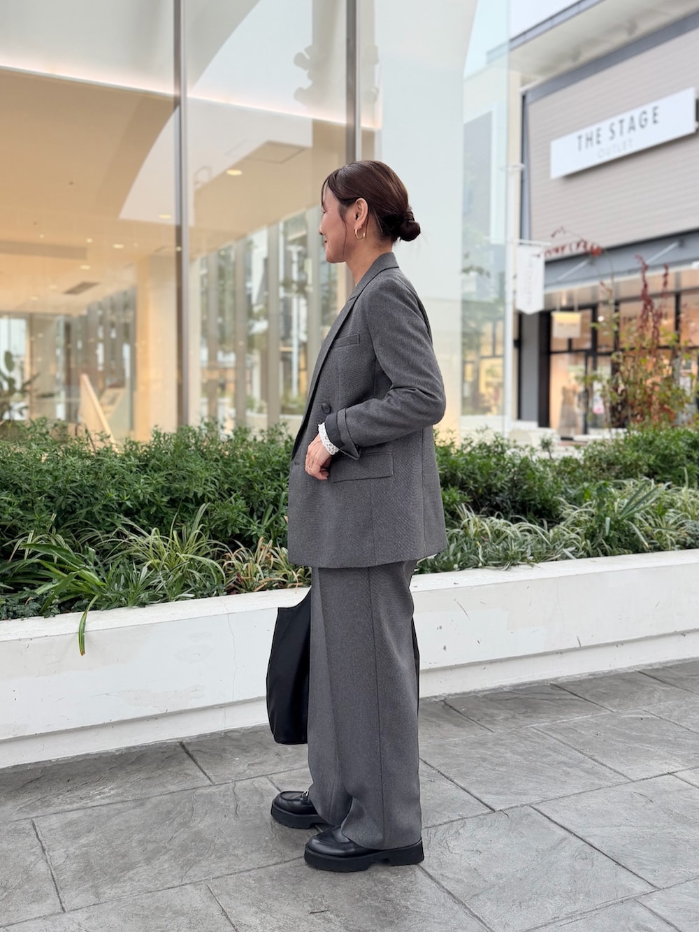 ブラック系のその他パンツ、ブラック系のトートバッグ、グレー系のTシャツ/カットソーを着用したレディースの秋コーディネートの2枚目の写真