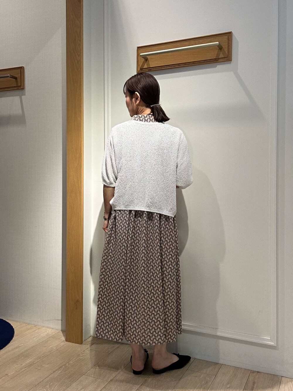 ベージュ系のワンピース、ホワイト系のカーディガン/ボレロ、ゴールド系のショルダーバッグを着用したレディースの春コーディネートの6枚目の写真