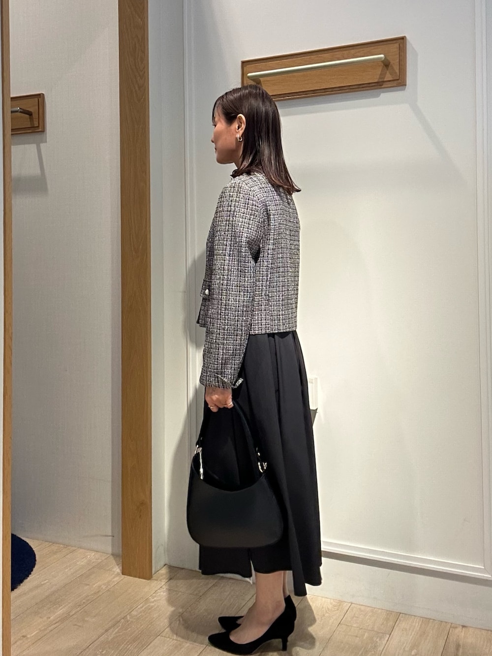 ブラック系のノーカラージャケット、ブラック系のTシャツ/カットソー、ブルー系のスカートを着用したレディースの冬コーディネートの2枚目の写真