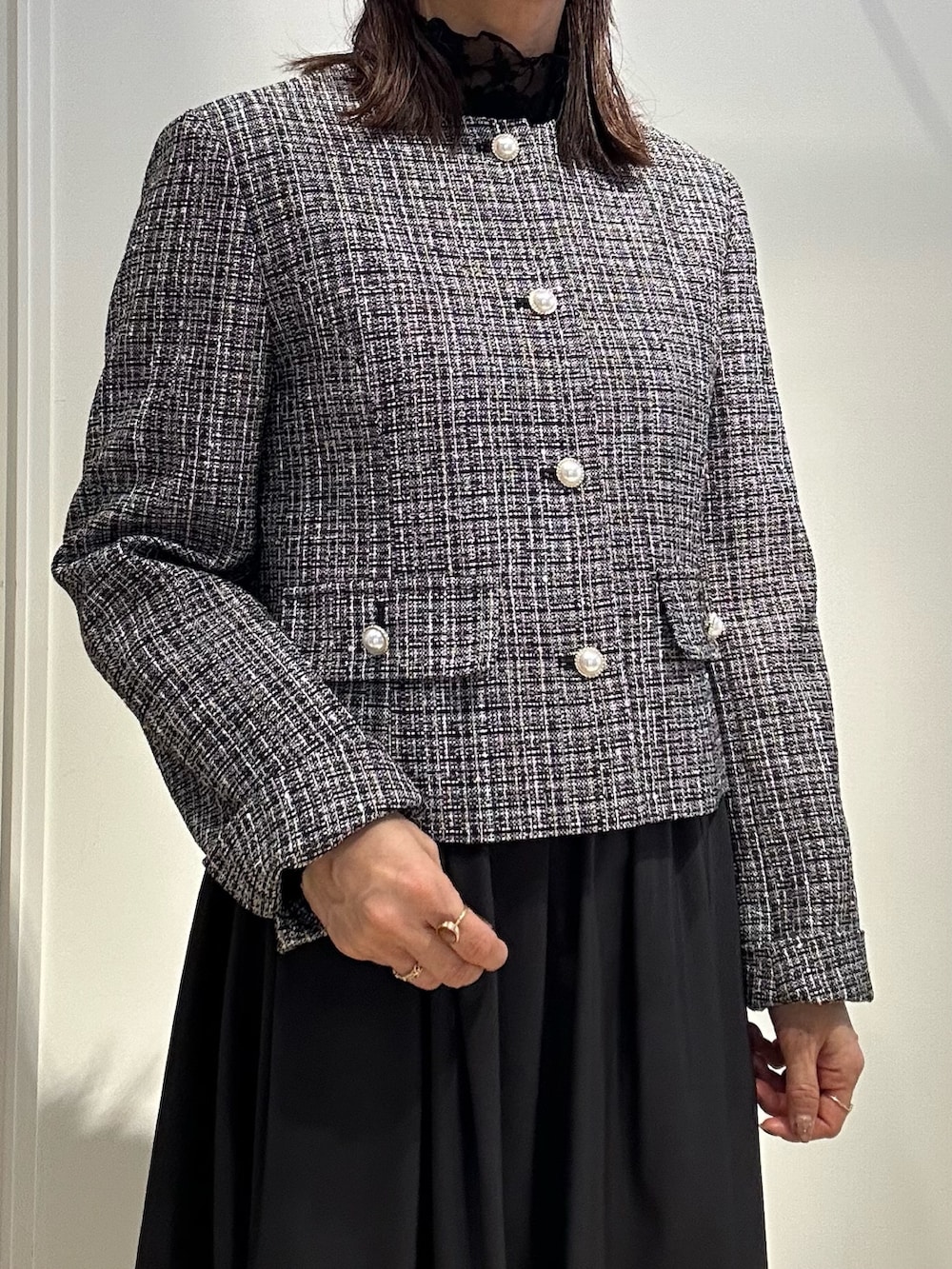 ブラック系のノーカラージャケット、ブラック系のTシャツ/カットソー、ブルー系のスカートを着用したレディースの冬コーディネートの5枚目の写真