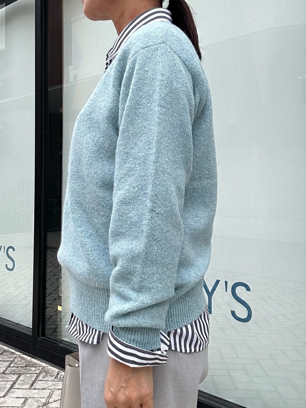 ブルー系のニット/セーター、グレー系のその他パンツ、ブラック系のシャツ/ブラウスを着用したレディースの秋コーディネートの7枚目の写真