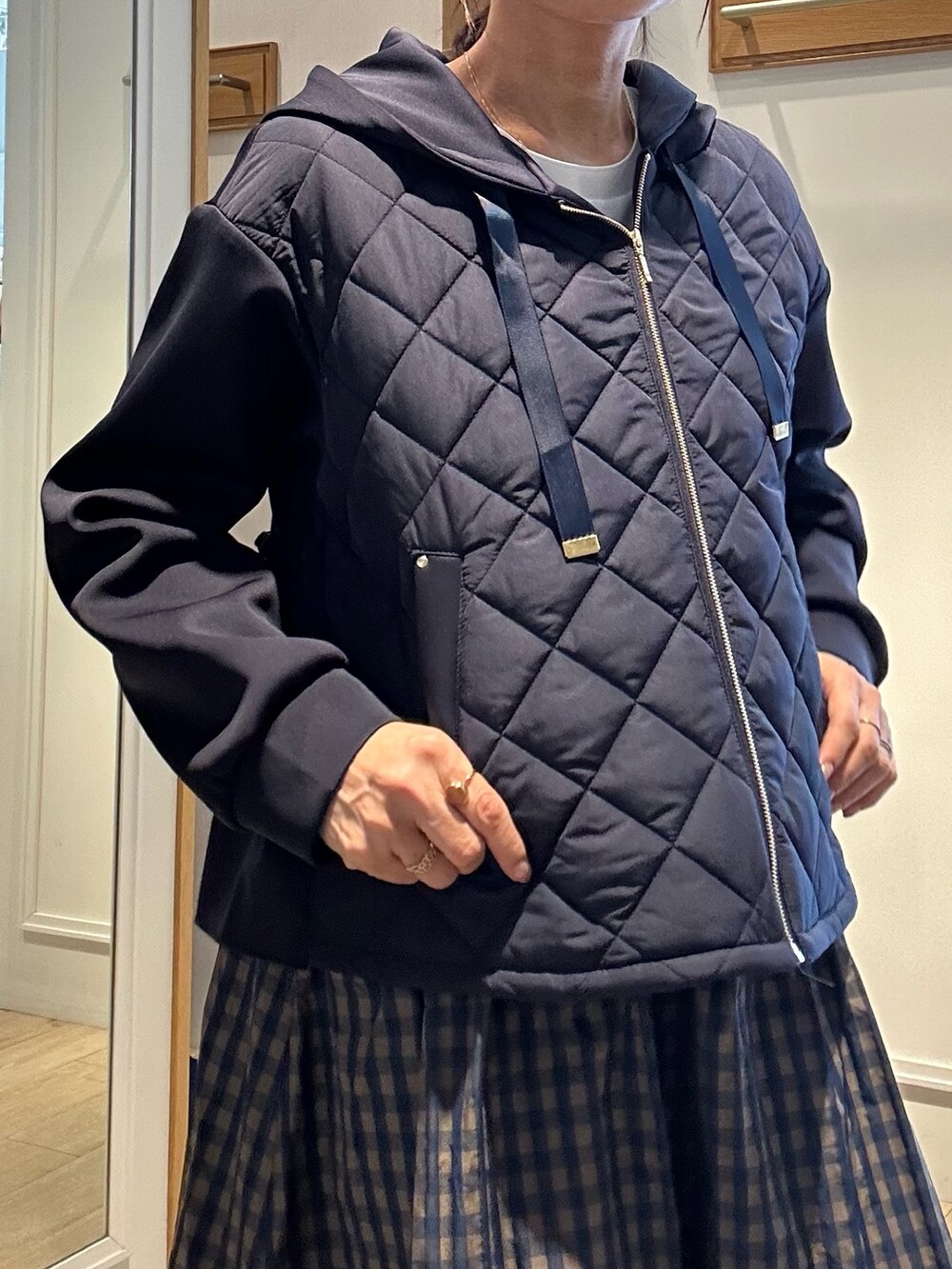 ホワイト系のTシャツ/カットソー、ブルー系のブルゾン、ブラウン系のスカートを着用したレディースの冬コーディネートの6枚目の写真