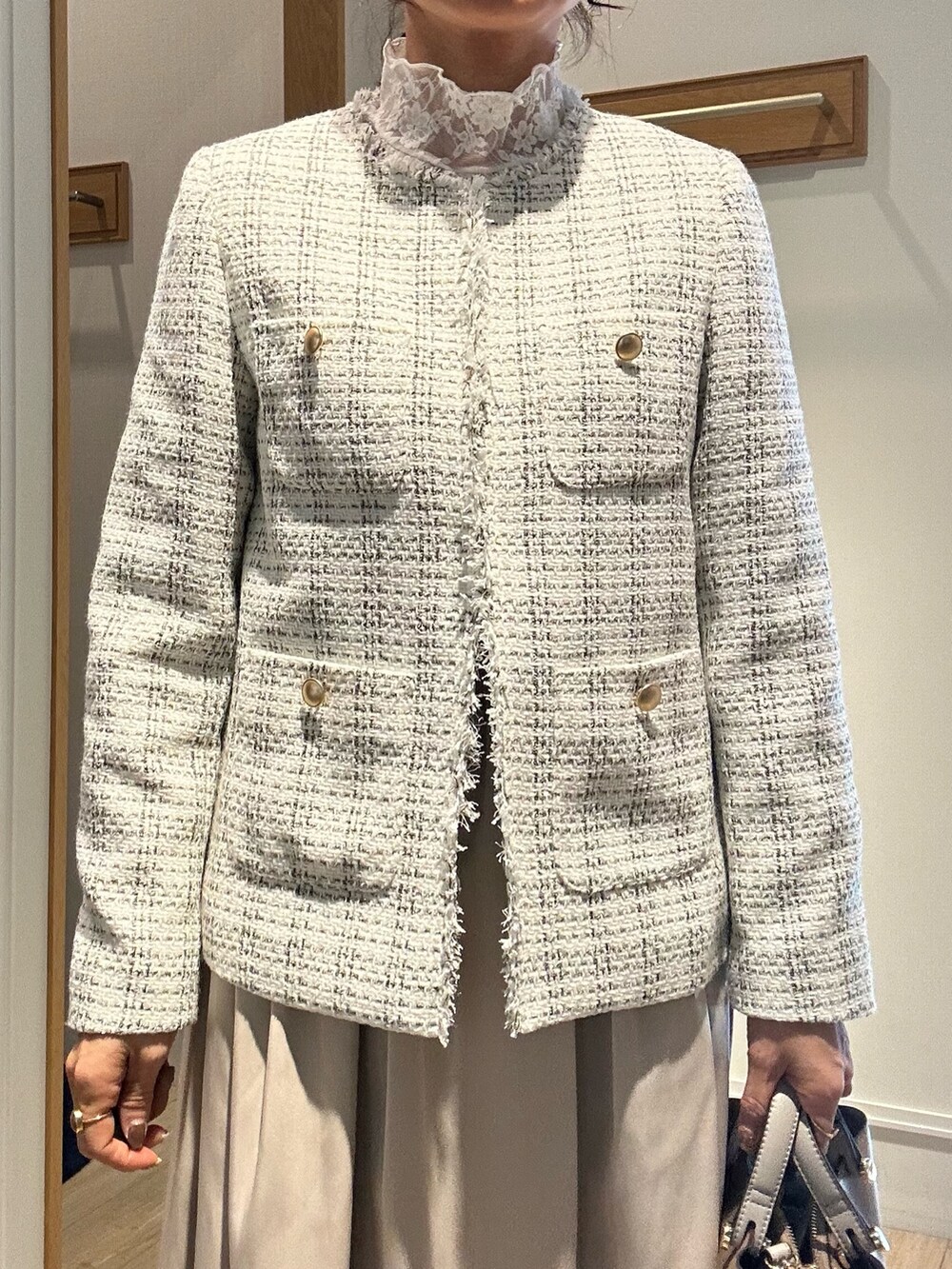 ホワイト系のノーカラージャケット、ベージュ系のスカート、ホワイト系のTシャツ/カットソーを着用したレディースの冬コーディネートの3枚目の写真