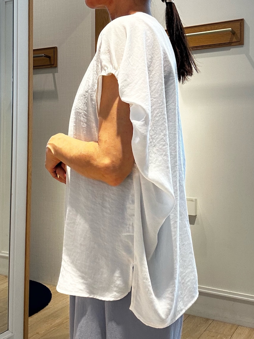 ホワイト系のシャツ/ブラウス、グレー系のダウンジャケット/コート、グレー系のその他パンツを着用したレディースの夏コーディネートの6枚目の写真